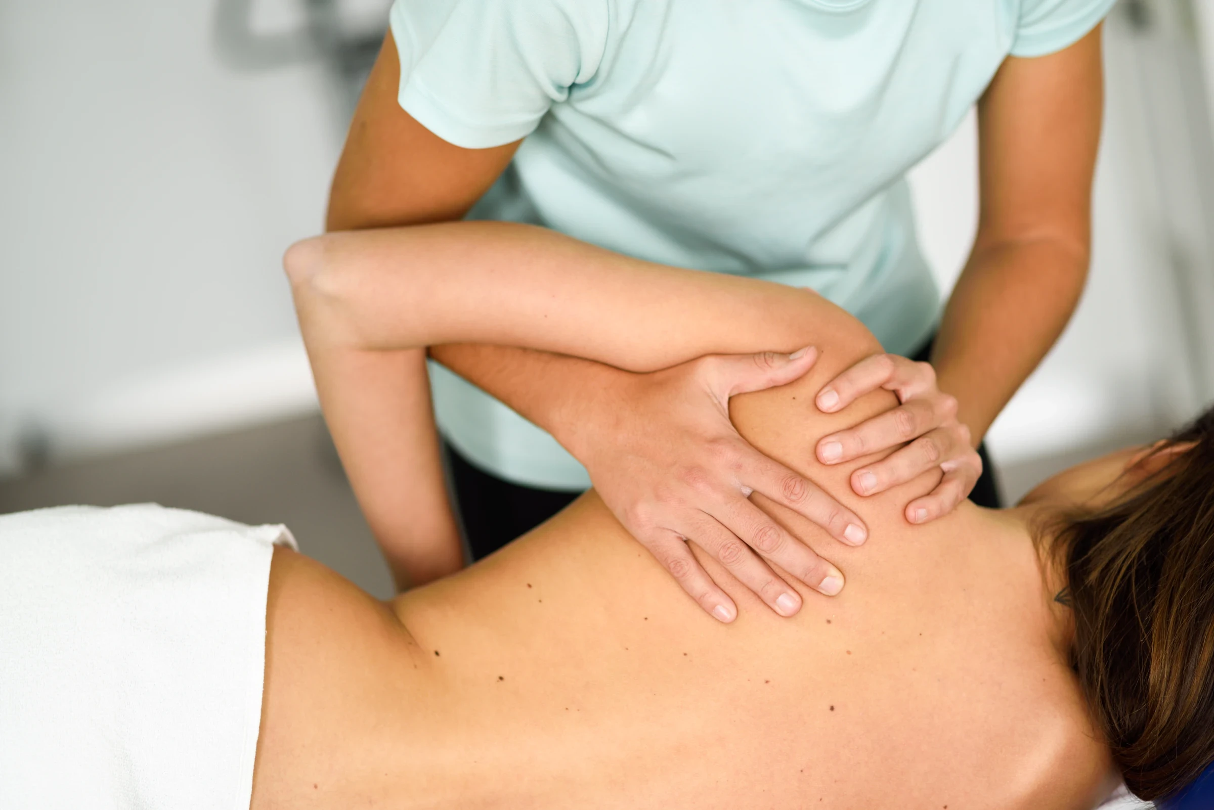 Osteopathic hands-on treatment of the client's shoulder and upper back